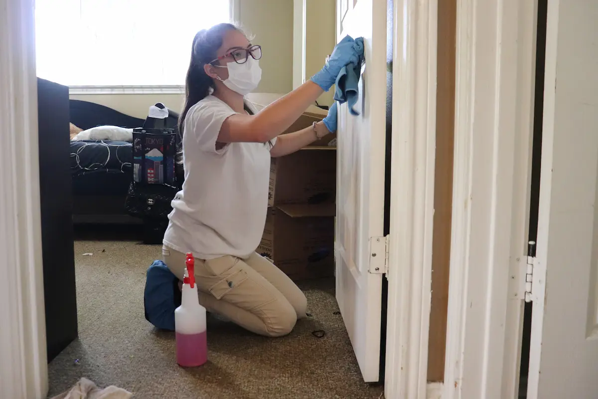 Miracle Cleaning Pros cleaner wiping down a bedroom door